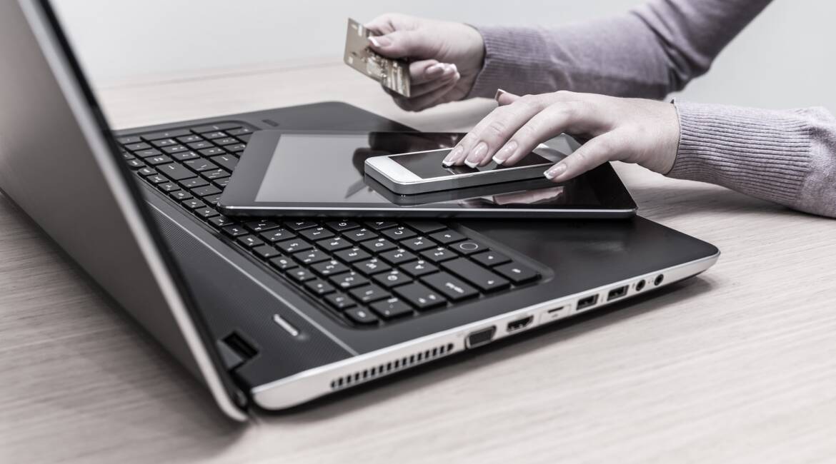 Мобилна версия на уебсайт изображение на жена, която е поставила мобилните си устройства и кредитната си карта върху лаптопа